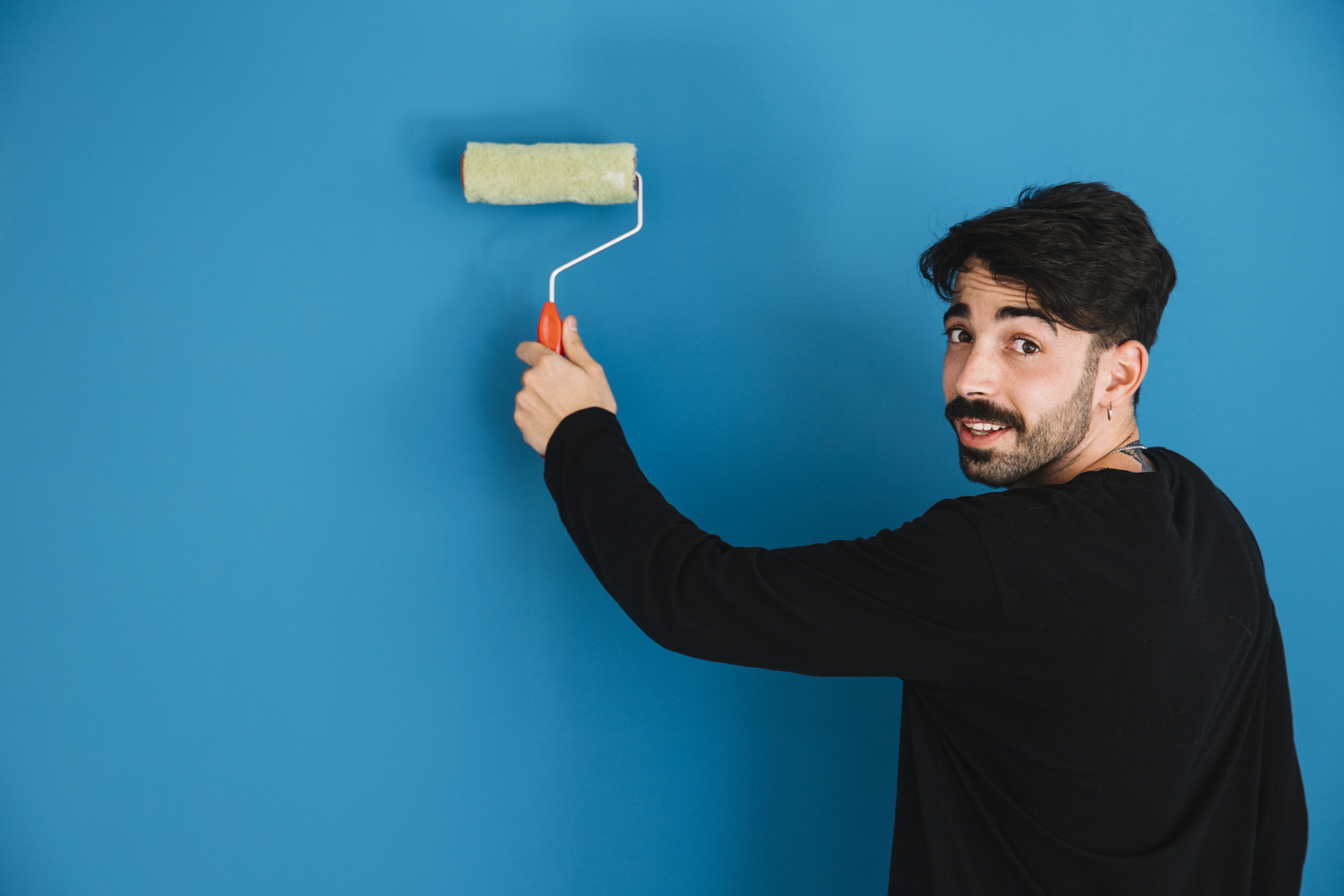 young man painting wall